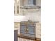 Elegant kitchen with white cabinetry, brass hardware, a blue range, and marble countertops at 32-E Prioleau St, Charleston, SC 29401