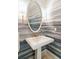 Stylish powder room featuring an oval mirror, unique wallpaper, and elegant sconces at 32-E Prioleau St, Charleston, SC 29401