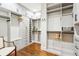Spacious walk-in closet with custom shelving, hanging rods, drawers, and hardwood floors at 32-E Prioleau St, Charleston, SC 29401