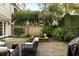 Backyard with stone patio, water feature, and lounge seating surrounded by greenery at 35 Tradd St, Charleston, SC 29401
