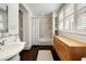 Bright bathroom with natural light, wood floors, vanity, and a shower with white tile at 35 Tradd St, Charleston, SC 29401