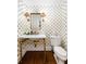 Charming powder room featuring pineapple wallpaper, brass fixtures, and marble countertop at 35 Tradd St, Charleston, SC 29401