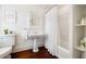 Bathroom featuring a pedestal sink, white tiled shower, and stylish white finishes at 35 Tradd St, Charleston, SC 29401
