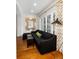 Cozy living room with hardwood floors, black sofa, and stylish gold mirror and accents at 35 Tradd St, Charleston, SC 29401