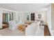 Bright, open living room with white sofas, unique wood coffee table and seamless flow to other rooms at 35 Tradd St, Charleston, SC 29401