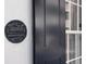 Close-up of a historic plaque next to a black shutter on a white building at 35 Tradd St, Charleston, SC 29401