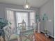 Bright dining area with modern light fixture, stylish glass table, seating for four, and bright natural lighting at 409 Reserve Way, Summerville, SC 29485