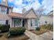 Charming two-story townhome with tan siding, mature landscaping, and a cozy front porch, ideal for relaxing outdoors at 409 Reserve Way, Summerville, SC 29485