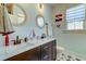 Nautical-themed bathroom featuring dual sinks, decorative mirrors, and patterned tile flooring at 418 Myers Mayo Rd, Ridgeville, SC 29472