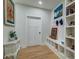 Hallway with a built-in bench and storage, light wood floors and white trim at 418 Myers Mayo Rd, Ridgeville, SC 29472