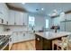 Modern kitchen with white cabinets, stainless steel appliances, and an island with seating at 418 Myers Mayo Rd, Ridgeville, SC 29472