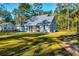 Home exterior showcasing a screened porch, spacious yard, and serene natural surroundings at 418 Myers Mayo Rd, Ridgeville, SC 29472