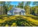 Exterior shot of the house featuring a screened-in porch and a lush green backyard at 418 Myers Mayo Rd, Ridgeville, SC 29472