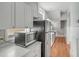 A long kitchen features stainless steel appliances, white cabinets and countertops, and hardwood floors at 47 Ashley Ave, Charleston, SC 29401