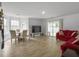 Open-concept living room with hardwood floors and large windows, seamlessly connecting to the outdoors at 4875 Carnoustie Ct, Summerville, SC 29485