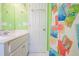 Bathroom with a tropical-themed shower curtain, white tile floors, and a white sink vanity at 507 Pompano St # 1/3 Share, Edisto Island, SC 29438