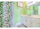 Bathroom with green walls, a floral shower curtain, white tile floors, and a white sink vanity at 507 Pompano St # 1/3 Share, Edisto Island, SC 29438