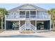 Beach house featuring a covered porch, white railings, ground-level parking, and stairs to the entrance at 507 Pompano St # 1/3 Share, Edisto Island, SC 29438