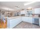 Bright kitchen with white cabinetry, stainless steel appliances, and a large island with a view to the dining area at 6024 Meadowcliff Ave, Hanahan, SC 29410