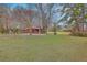 Expansive backyard with mature trees, a grassy lawn, and a charming house in the background at 7 Dogwood Ln, Walterboro, SC 29488