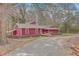 A view of the red house with lovely landscaping featuring a well-maintained garden and a gravel driveway at 7 Dogwood Ln, Walterboro, SC 29488