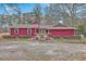 Charming red home featuring well-maintained landscaping and a welcoming entrance with double doors and mature trees at 7 Dogwood Ln, Walterboro, SC 29488