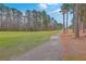 Beautiful golf course featuring a paved path, lush green grass, and tall trees at 7 Dogwood Ln, Walterboro, SC 29488