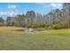 Picturesque pond with a fountain feature surrounded by manicured green grass and mature trees at 7 Dogwood Ln, Walterboro, SC 29488