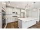 A spacious white kitchen features stainless steel appliances, a subway tile backsplash, and an island with pendant lighting at 714 Breakers Reef Ln, Huger, SC 29450