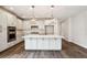 Modern kitchen features a large island with marble countertop, stainless steel appliances, and gray wood flooring at 714 Breakers Reef Ln, Huger, SC 29450
