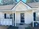 Welcoming front entrance of home featuring a covered porch, white columns, and ADT security sign at 7364 Suncatcher Dr, Hanahan, SC 29410
