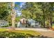 Charming white home featuring a striking red door, complemented by an upper-level deck and attached garages at 781 E Butternut Rd, Summerville, SC 29483