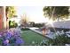 Picturesque backyard with a pool, lounge chairs, covered seating area, and vibrant floral landscaping at 80 Smith St, Charleston, SC 29401