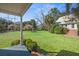 Expansive backyard with lush green grass, mature trees, and a covered porch at 901 Morton Waring Ln, Pinopolis, SC 29469