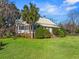 Classic home exterior features a lush lawn, mature trees, and well-manicured shrubbery at 901 Morton Waring Ln, Pinopolis, SC 29469