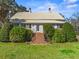 Charming exterior with brick steps, a metal roof and manicured shrubbery at 901 Morton Waring Ln, Pinopolis, SC 29469