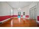 Open living room with hardwood floors, red wainscoting, and natural light from large windows at 901 Morton Waring Ln, Pinopolis, SC 29469