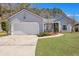 Charming single-story home featuring manicured lawn, tidy landscaping, and attached two-car garage at 106 Ranworth Ln, Summerville, SC 29485