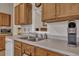 Kitchen sink area with stainless steel faucet, wooden cabinets, and a Keurig coffee machine at 106 Ranworth Ln, Summerville, SC 29485