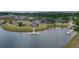 Scenic aerial view of a lakeside community showcasing a clubhouse, tennis courts, and walking paths amidst lush landscaping at 115 Bluff Isle Ct, Summerville, SC 29486