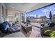 Screened-in porch with wicker furniture, an outdoor rug, and a picturesque view of a pond and palm trees at 115 Bluff Isle Ct, Summerville, SC 29486