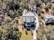 Aerial view of a landscaped property with mature trees, a driveway, and a detached garage at 129 Sparrow Dr, Isle of Palms, SC 29451