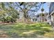 Expansive backyard with mature trees, lush lawn, and inviting outdoor seating area at 129 Sparrow Dr, Isle of Palms, SC 29451