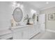 Elegant bathroom featuring dual sinks, quartz countertops, shiplap walls and oval mirrors at 129 Sparrow Dr, Isle of Palms, SC 29451