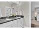 Bright bathroom featuring double sinks, dark countertops, and decorative yellow flowers at 129 Sparrow Dr, Isle of Palms, SC 29451