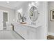 Elegant bathroom with dual sinks, quartz countertops, shiplap walls and oval mirrors at 129 Sparrow Dr, Isle of Palms, SC 29451