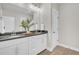 Modern bathroom featuring double sinks, dark countertops, white cabinets, and decorative green plants at 129 Sparrow Dr, Isle of Palms, SC 29451