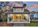 Charming exterior with inviting front porch framed by palm trees, offering a glimpse of the warm interior lighting at 129 Sparrow Dr, Isle of Palms, SC 29451