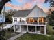 Stunning rear exterior view of a coastal home with an upper deck and lower level patio seating area at 129 Sparrow Dr, Isle of Palms, SC 29451