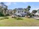 Charming two-story beach house with a welcoming front porch and lush landscaping at 129 Sparrow Dr, Isle of Palms, SC 29451